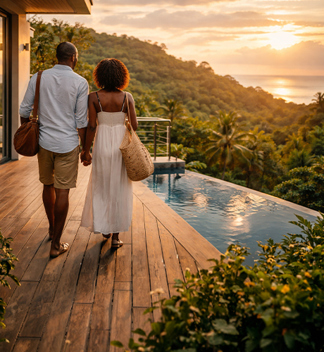 Black American couple walking outside modern home in Costa Rica with rainforest and ocean view at sunset